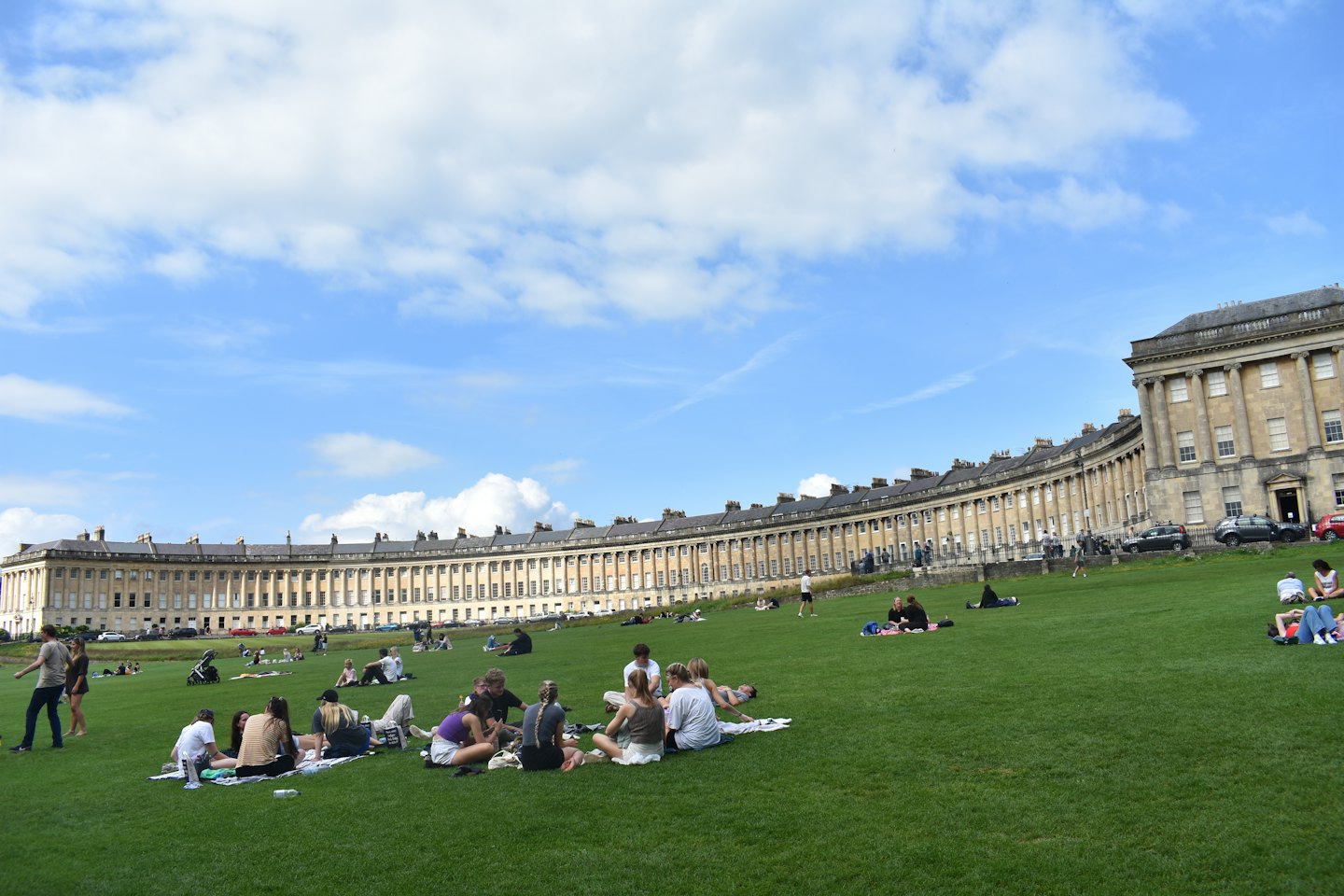 Young adults enjoying a sunny day on a green lawn.