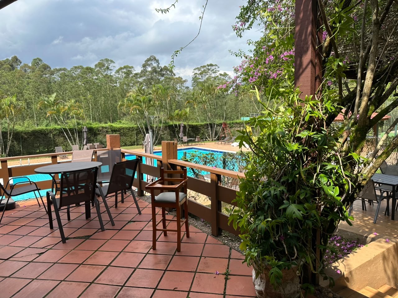 Residential apartment complex with a pool and surrounding trees.